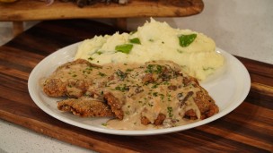 Milanesa de entraña con salsa de hongo y puré de papa