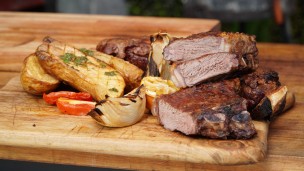 Distintos cortes de asado con vegetales asados y ensalada 