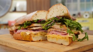 Sándwich de cerdo con pepinos, jamón y queso